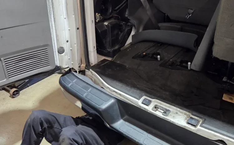 Open van rear with technician under dash at Sanfelippo Auto Repair site.