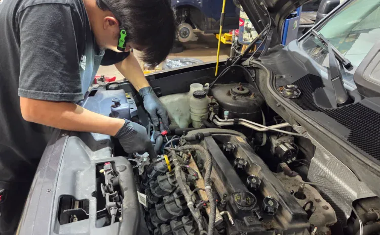 Technician inspecting car engine at Sanfelippo Auto Repair.