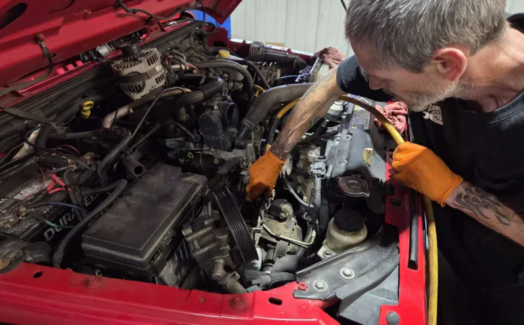 Technician inspecting car engine during repair at Sanfelippo Auto Repair.