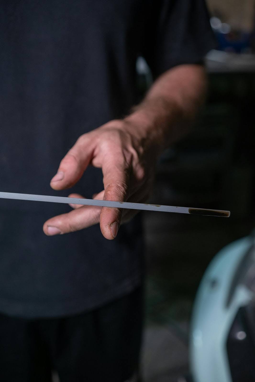 Transmission repair technician inspecting a metal tool for issues.