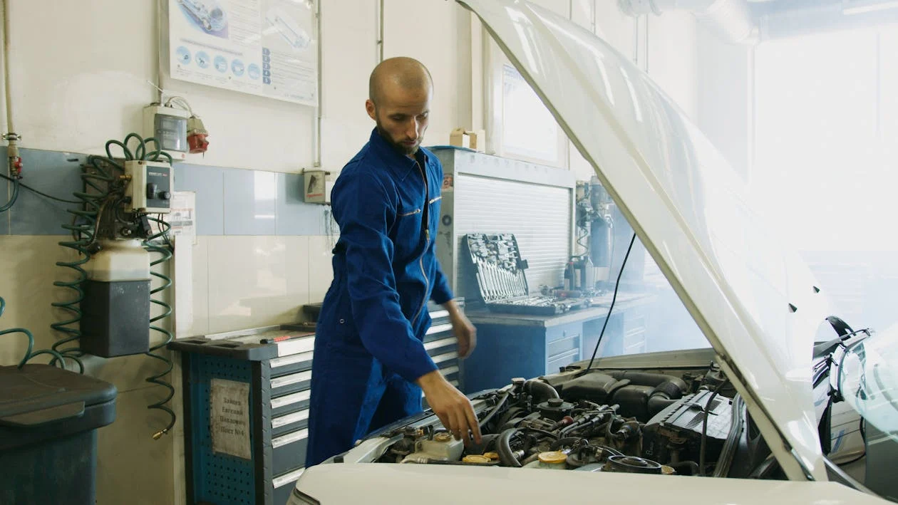 Auto mechanic inspecting engine for fuel efficiency improvements.