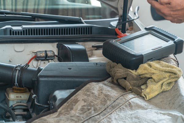 Vehicle diagnostic scanner on a truck engine for fleet management.