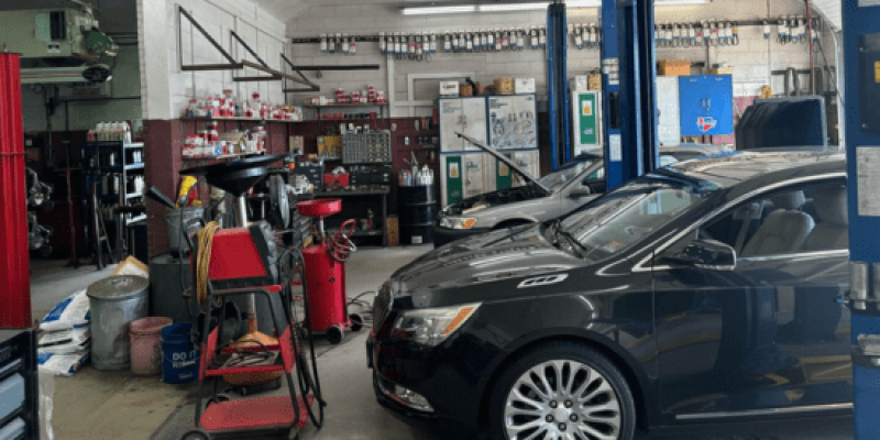 Modern automotive repair shop with cars and tools inside.
