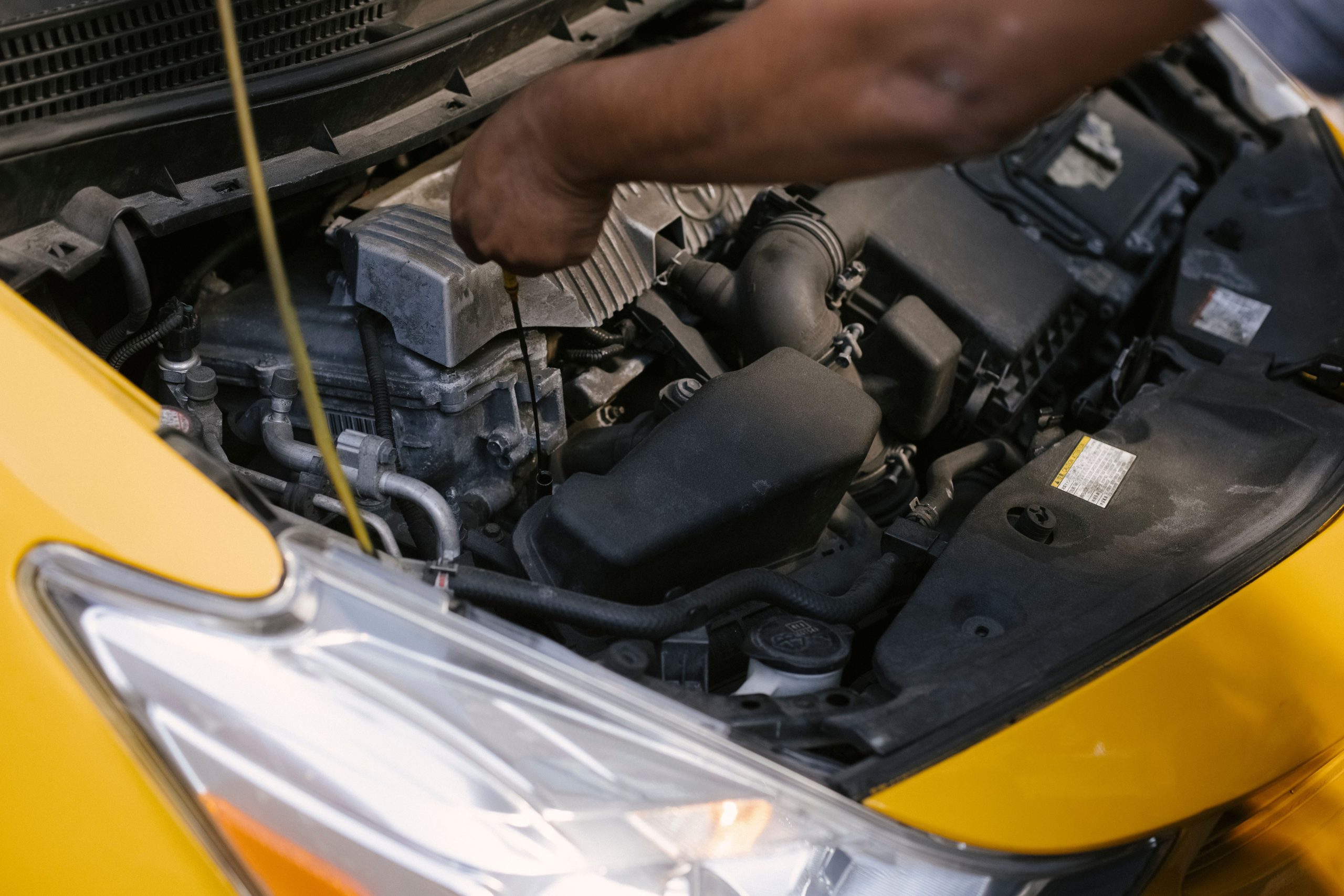 Technician inspecting car engine at Sedona Oil & Lube.