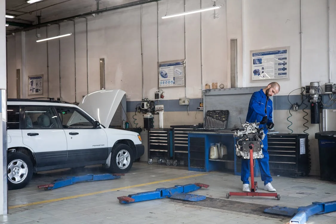 Auto repair technician inspecting a vehicle at Senshine Autos workshop.