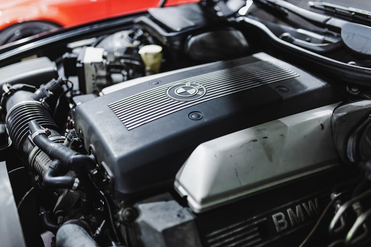 Close-up of BMW engine showing detailed engine parts and branding.