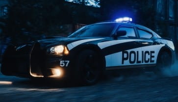 Police vehicle with flashing lights during night patrol, emphasizing law enforcement presence.