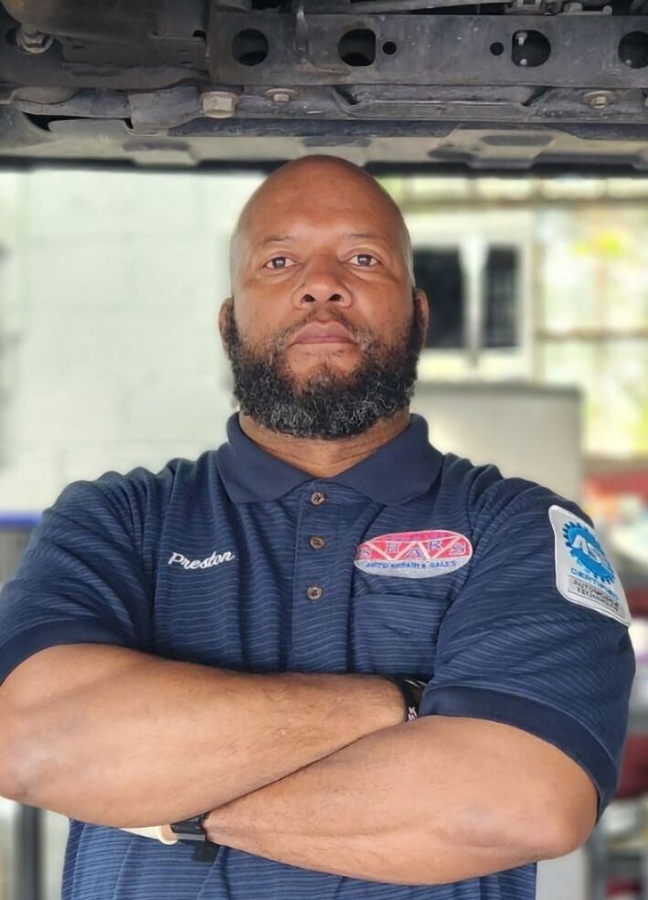 Auto repair technician with arms crossed at Silver Hill Auto Repair.