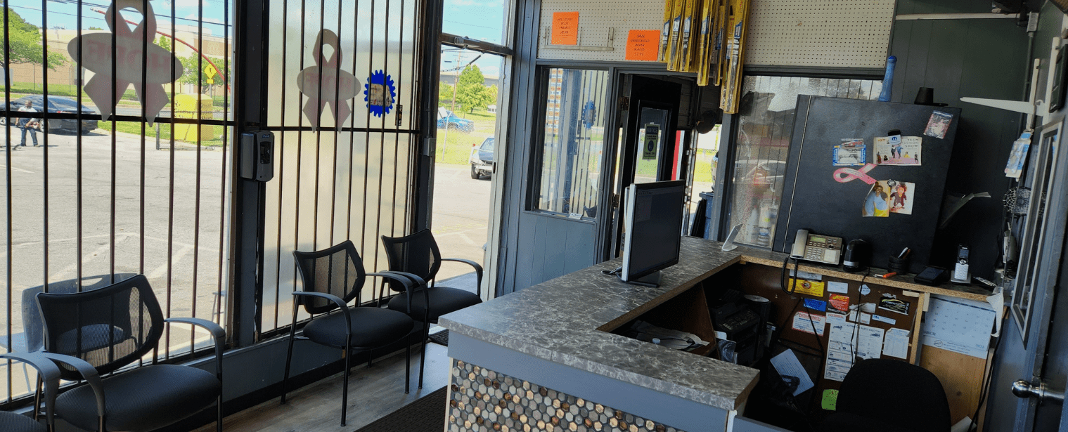 Auto repair shop reception with chairs and service counter.