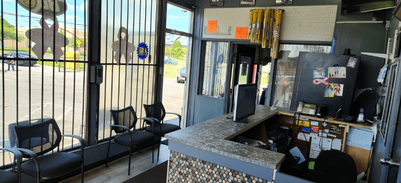 Auto repair shop waiting area with seating and service counter.