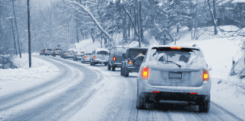 Winter driving safety with snow-covered roads and vehicles.