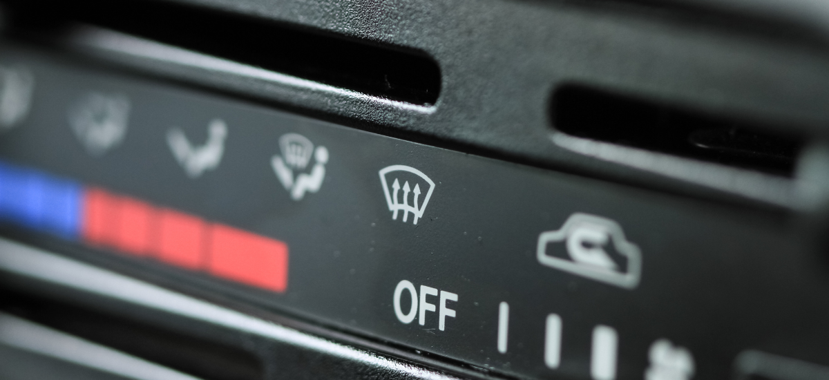 Car AC control panel with defrost and ventilation settings.