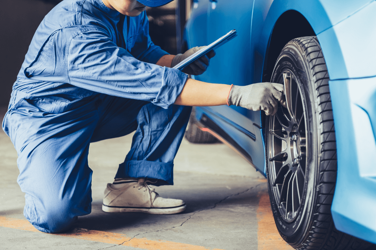Technician inspecting a car tire during maintenance at Silver Hill Auto Repair.