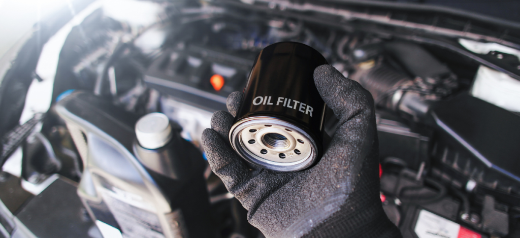Oil filter being replaced in a vehicle engine for optimal performance and longevity.