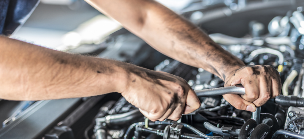 Technician performing vehicle diagnostics to ensure optimal engine performance.