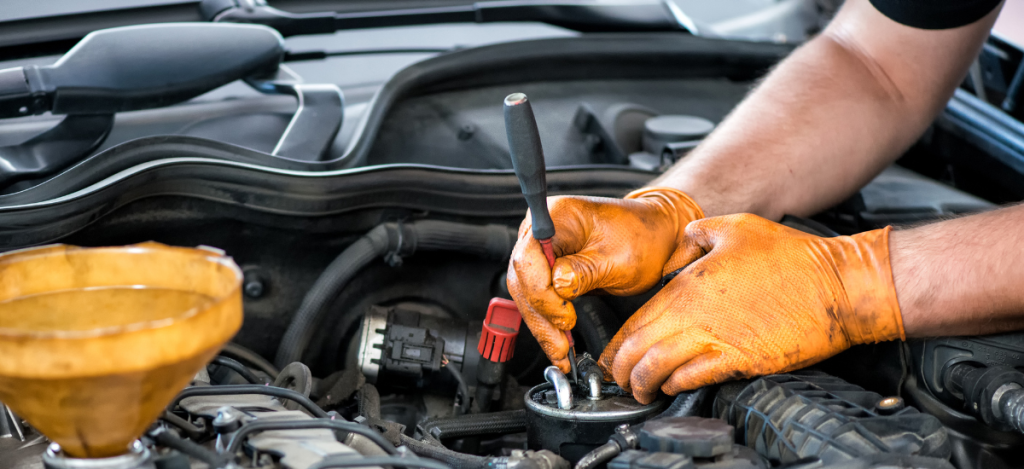 Technician performing vehicle diagnostics under the hood for optimal car health.