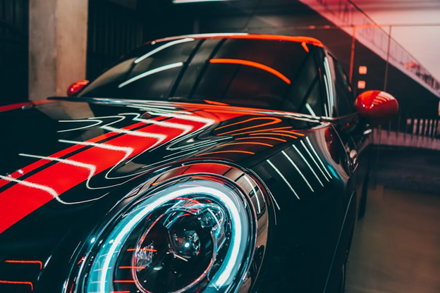 Modern black sports car with neon accents, highlighting vehicle noise issues.