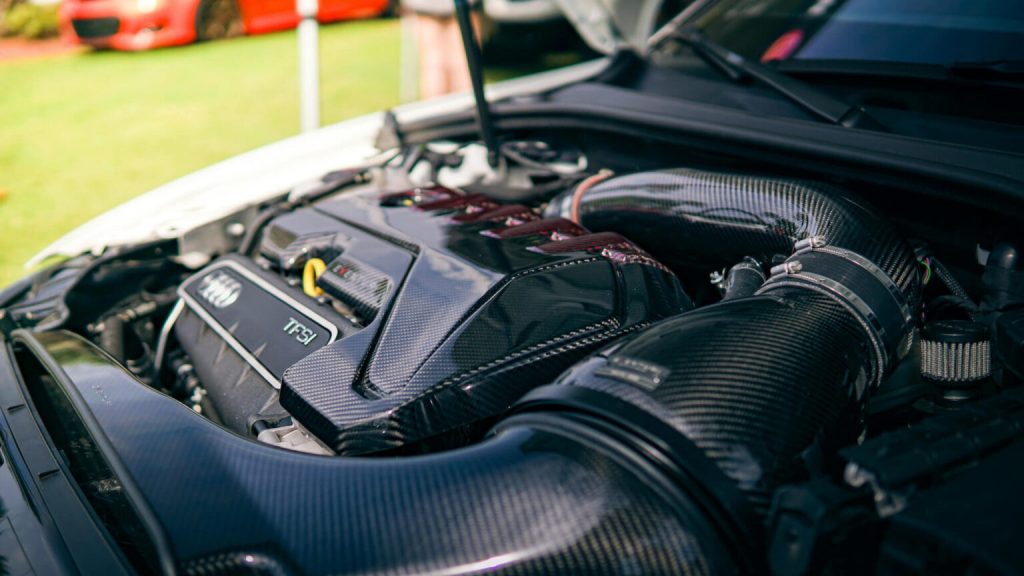 Close-up of a high-performance car engine with carbon fiber components.