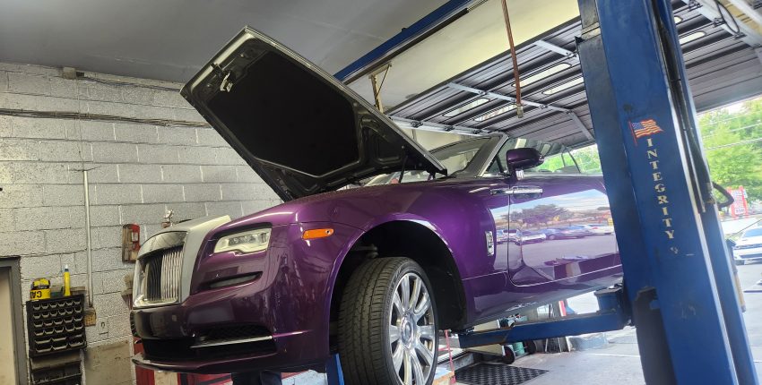 Purple luxury car elevated on lift at Silver Hill Auto Repair.