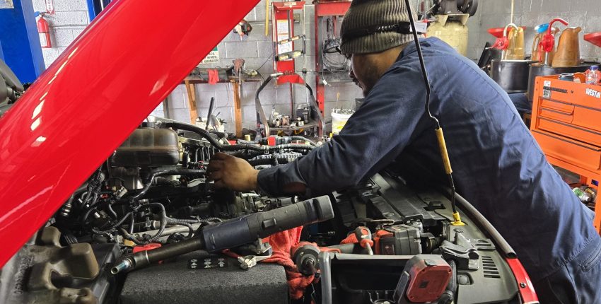 Technician inspecting car engine at Silver Hill Auto Repair.