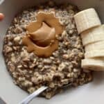 Creamy peanut butter oatmeal topped with a spoonful of peanut butter and sliced bananas in a white bowl. Healthy breakfast featuring oats, bananas, and natural peanut butter for energy and nutrition.