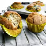 Freshly baked blueberry muffins on a cooling rack with a muffin pan in the background, showcasing delicious homemade breakfast or snack ideas for healthy eating.