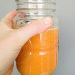 Freshly made orange sugar scrub in a clear jar, perfect for skincare and exfoliation, featuring natural ingredients like sugar and citrus for glowing skin.