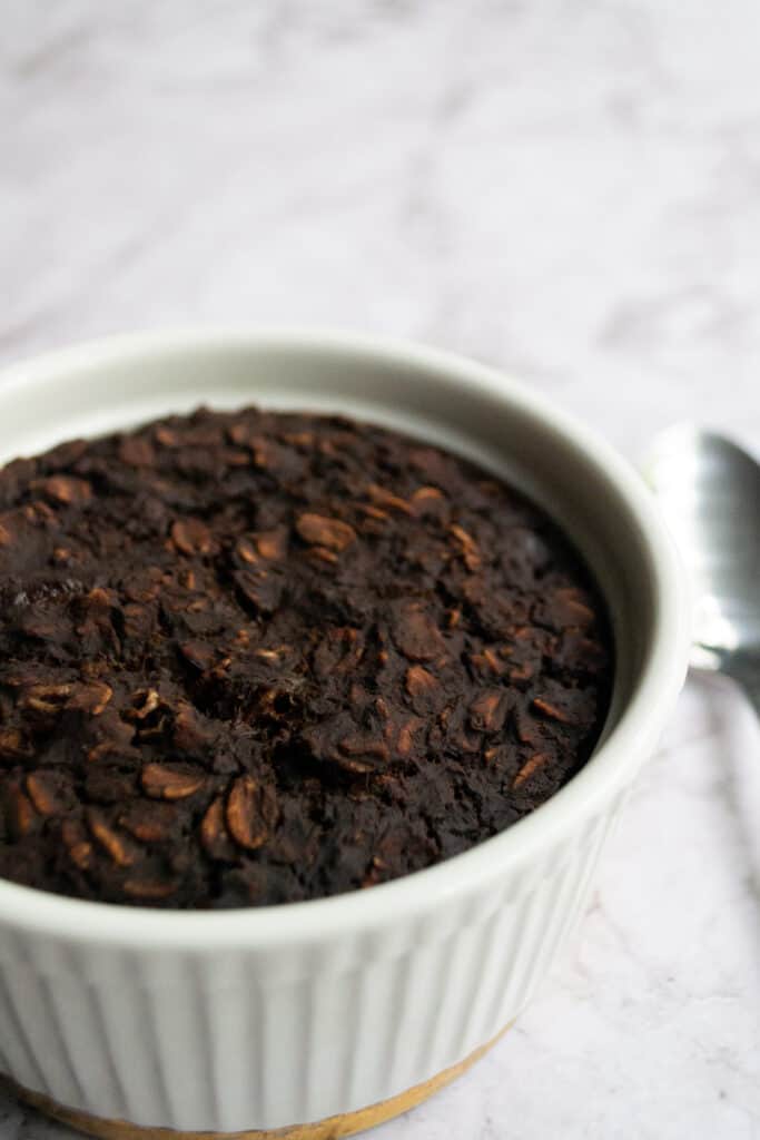 White ramekin with brownie batter baked oats inside.