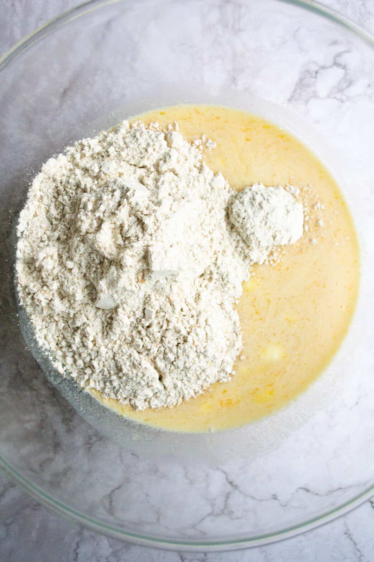 Flour and wet ingredients combined in a glass mixing bowl, ready for baking or cooking, showcasing fresh and wholesome ingredients for homemade recipes.