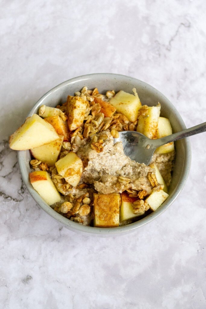 Top view of apple pie overnight oats in a bowl on a marble table.