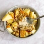 Cream of oats with fresh apple chunks and cinnamon in a bowl, healthy breakfast option, delicious oatmeal recipe, gluten-free oatmeal, nutritious morning meal.