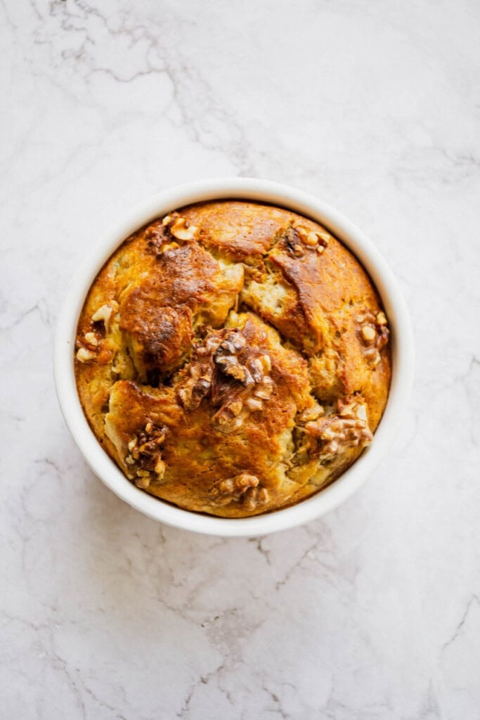 Overhead shot of a single serving banana bread made with egg on a marble table.