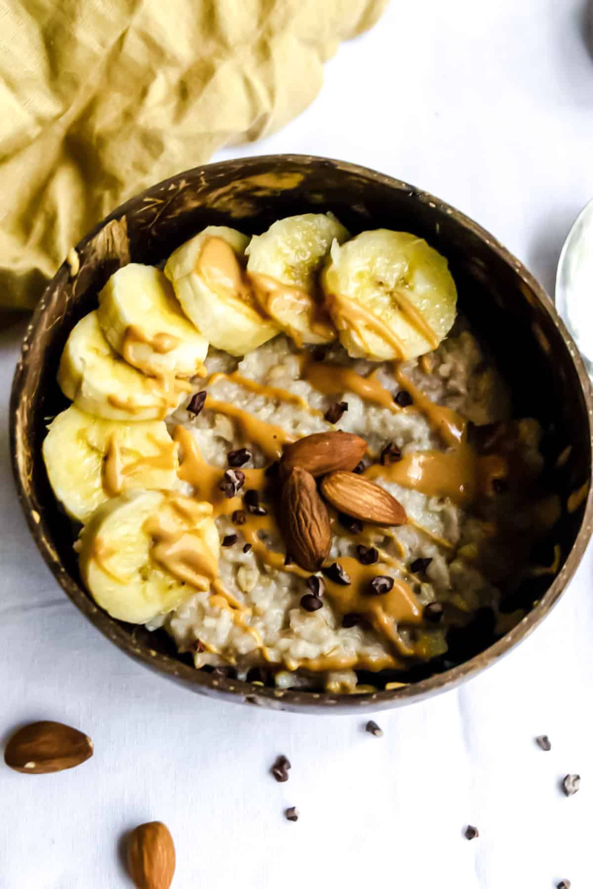 Overhead shot of PB2 oatmeal topped with banana, cacao and almonds.