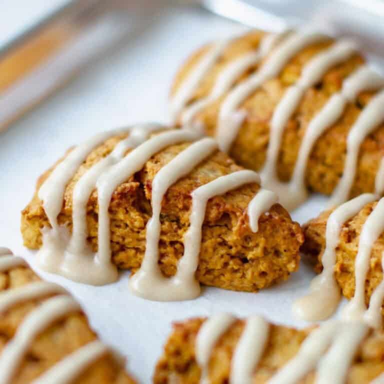 Warm, freshly baked carrot cake energy bites drizzled with creamy white icing. Perfect healthy snack or dessert with wholesome ingredients.
