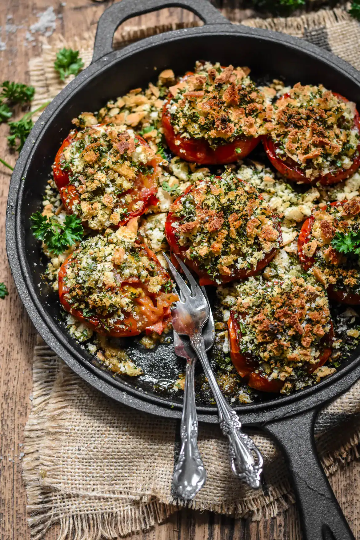 Overhead shot of provence-style baked tomatoes in a cast-iron pan.