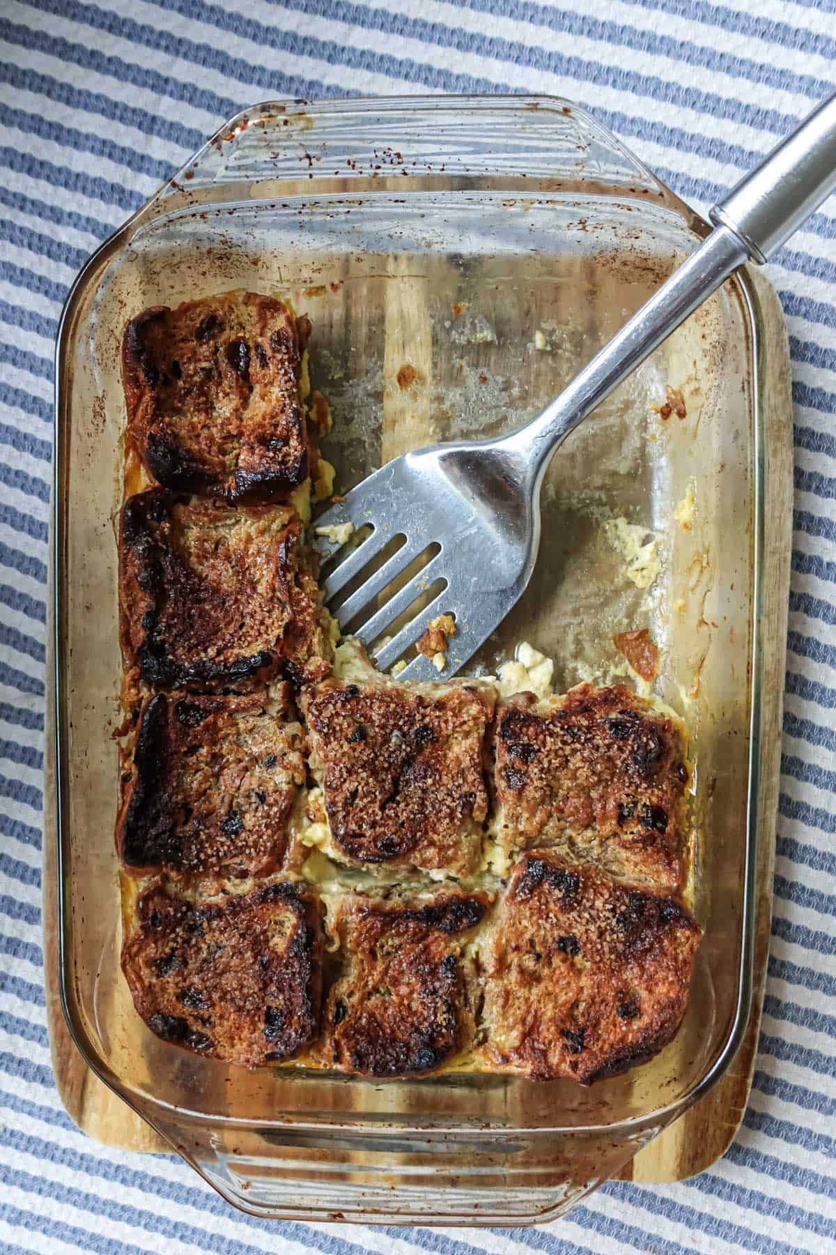 Golden-brown baked French toast casserole with crispy edges, served in a glass dish, perfect for brunch or breakfast, featured on Simply Fresh Foodie website.