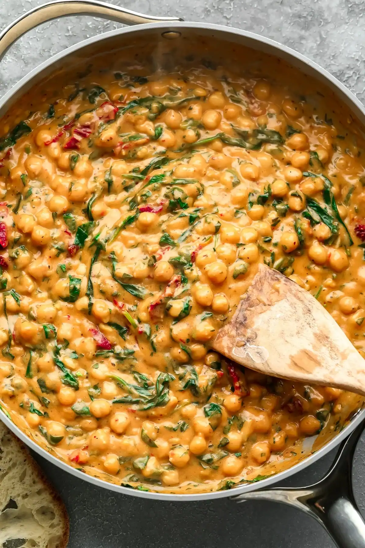 Creamy chickpea curry with spinach and red pepper flakes in a skillet, featuring a hearty, flavorful vegetarian dish perfect for healthy meal ideas.