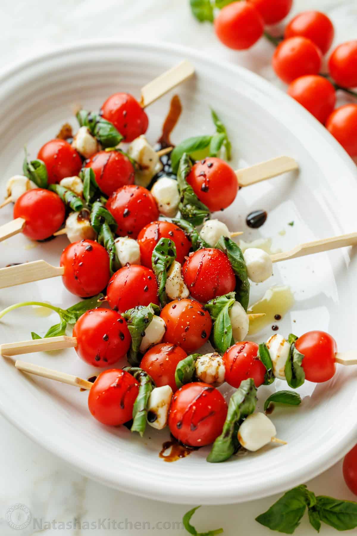 Cherry Caprese Skewers with fresh tomatoes, mozzarella, basil, and balsamic glaze. Perfect for appetizers or parties.
