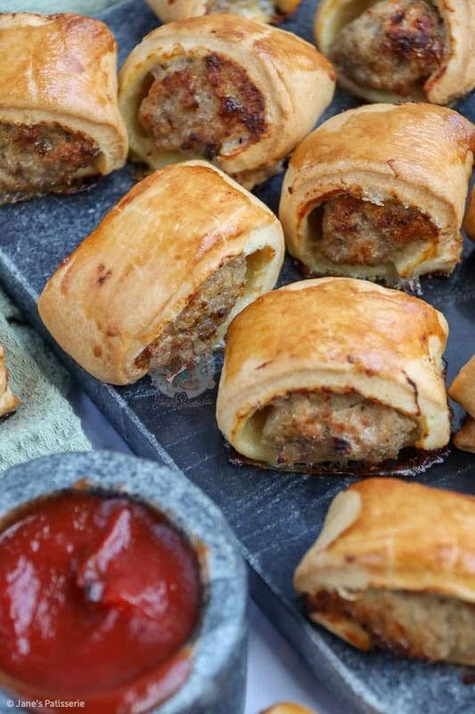 Golden sausage roll bites with flaky pastry and savory filling, perfect for appetizer or snack.