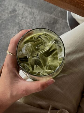 Refreshingly green iced matcha latte with ice cubes, showcasing a healthy, trendy beverage.