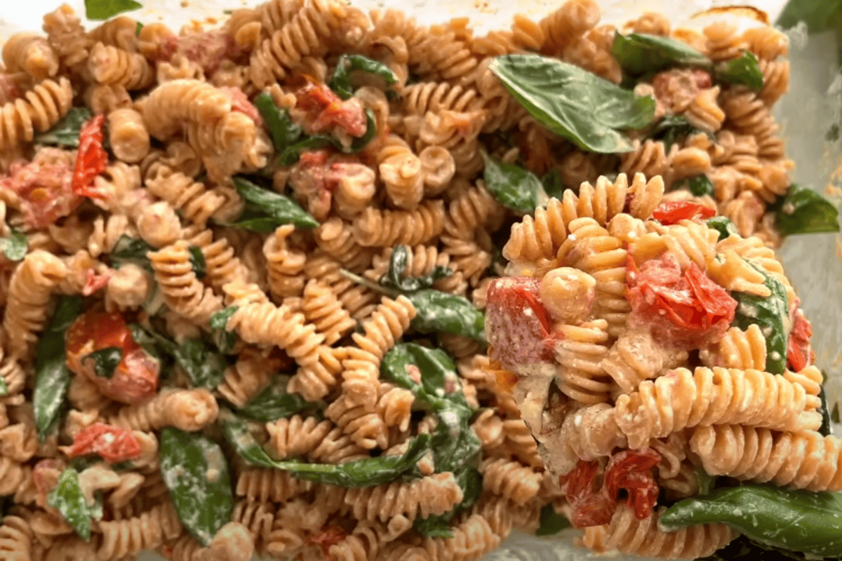 Savoury oven baked feta pasta with fusilli, cherry tomatoes, basil, and creamy sauce.