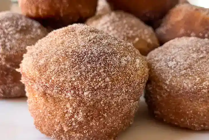 Golden cinnamon sugar donuts with a crispy exterior and soft inside, freshly baked for a delicious treat. Perfect for breakfast or snacks, topped with a sweet cinnamon coating.
