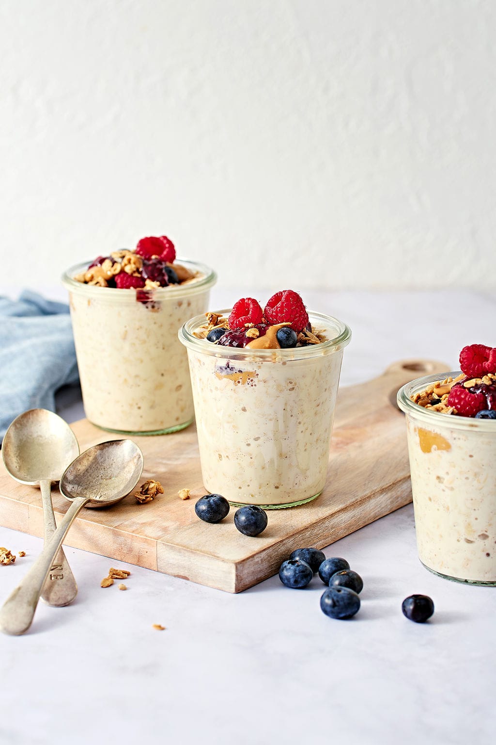 Creamy overnight oats in glass jars, topped with berries light background for healthy breakfast recipes, perfect for breakfast or snacks.