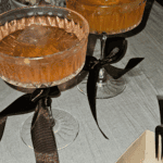 New Year's party champagne cocktails in fancy glasses with black ribbons around the stem.