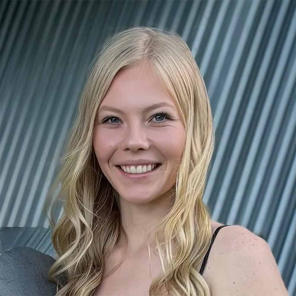 Professional woman smiling outdoors, representing innovative technology solutions by SNX Technologies.