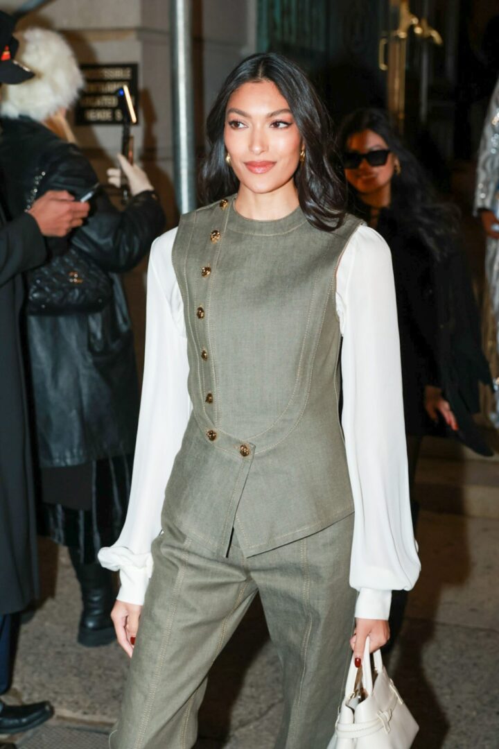 Elegant woman in olive green suit with white blouse on the street at New York Fashion Week