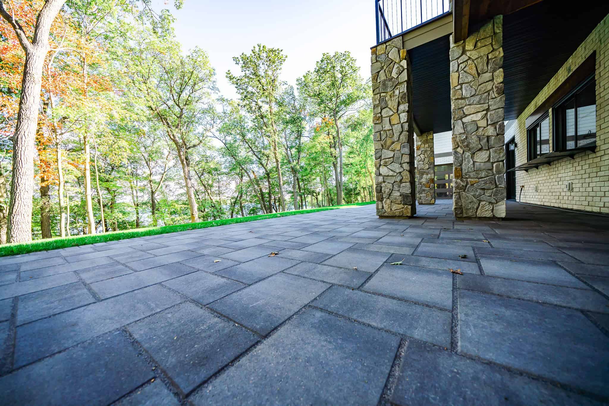Natural stone patio with lush green trees in the background, perfect for outdoor living and relaxation.
