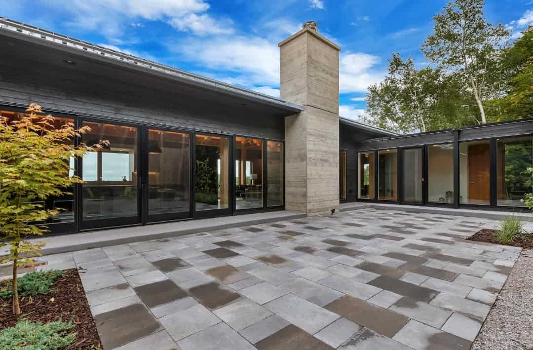 Sophisticated modern house with expansive patio and large glass windows for outdoor living.