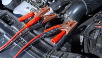 Heavy-duty car battery cables with red and black insulation for reliable power connection.