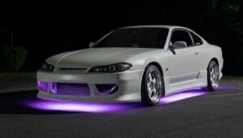 Custom white sports car with purple underglow lighting at Suttons Automotive.